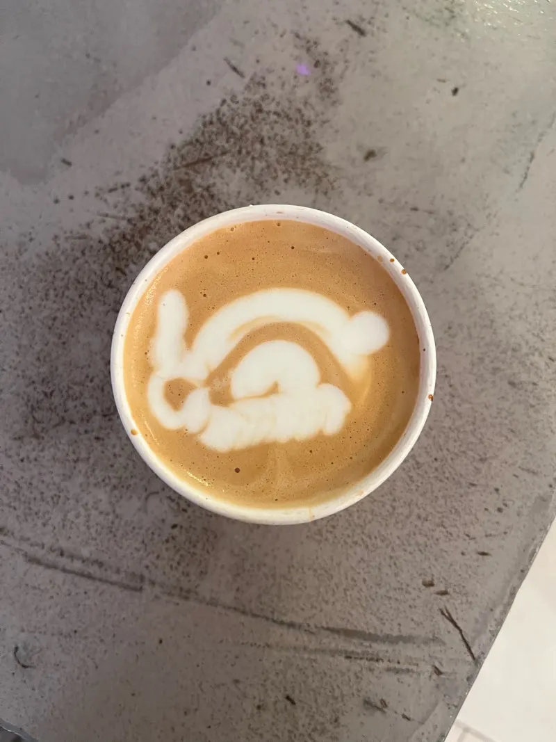 A latte with latte art on a stone table