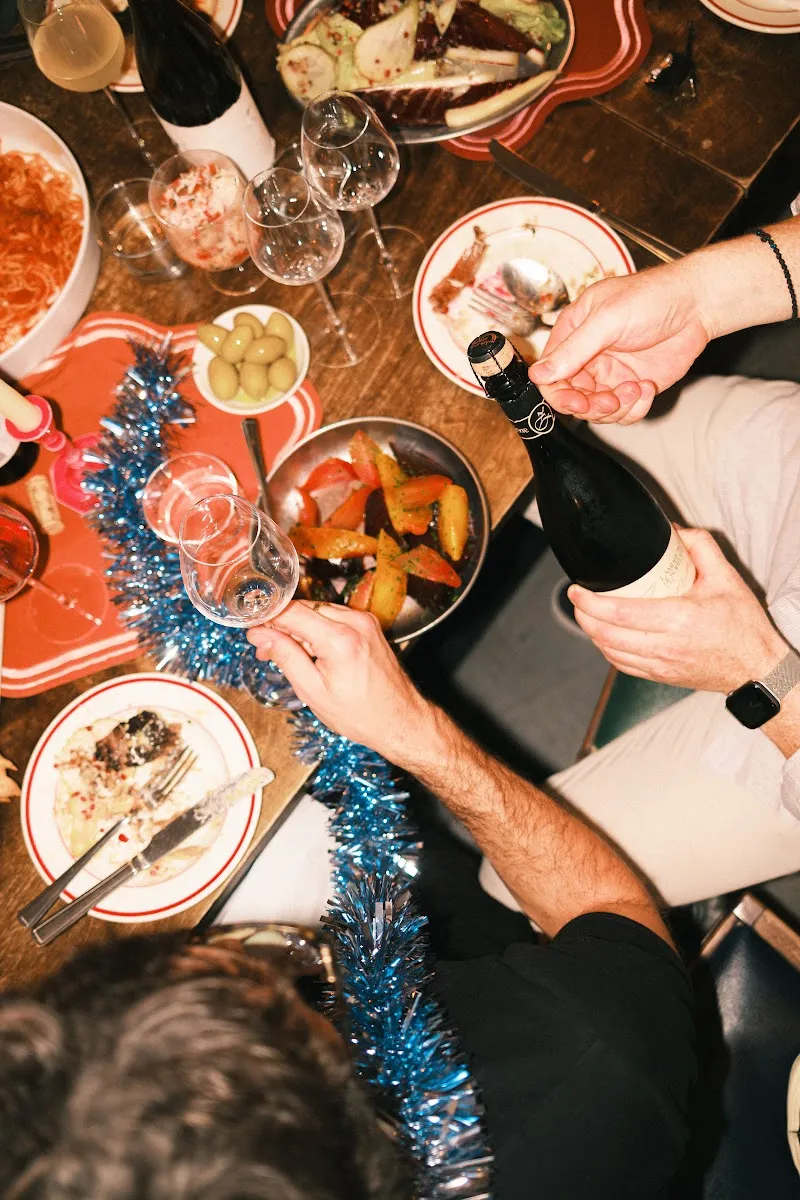 A Christmas dinner table with champagne being poured