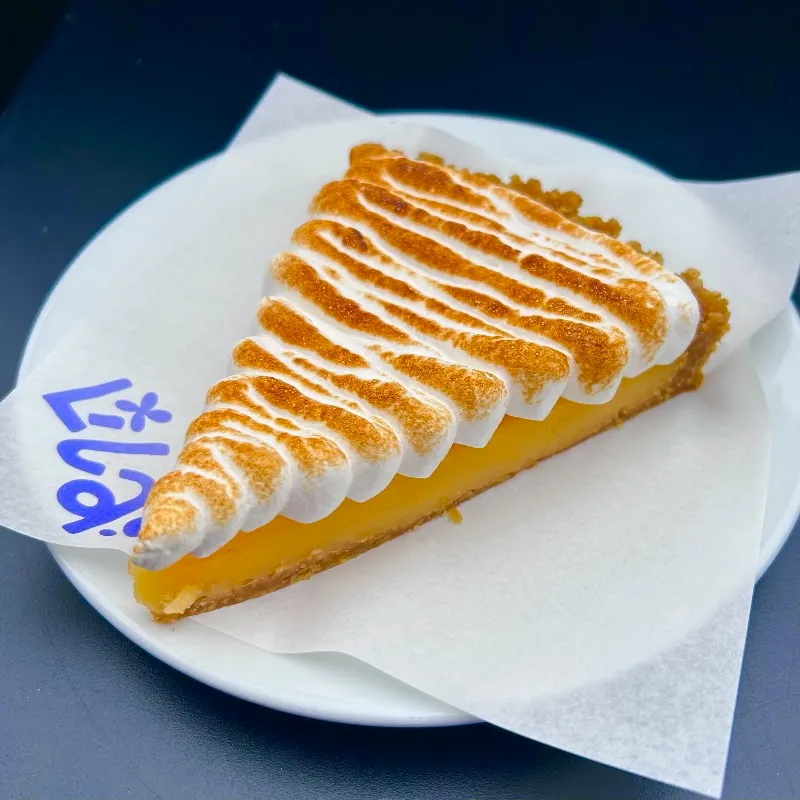 A slice of lemon meringue tart on a napkin