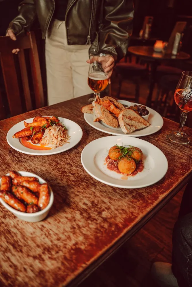 Plates of pub food on a wooden table