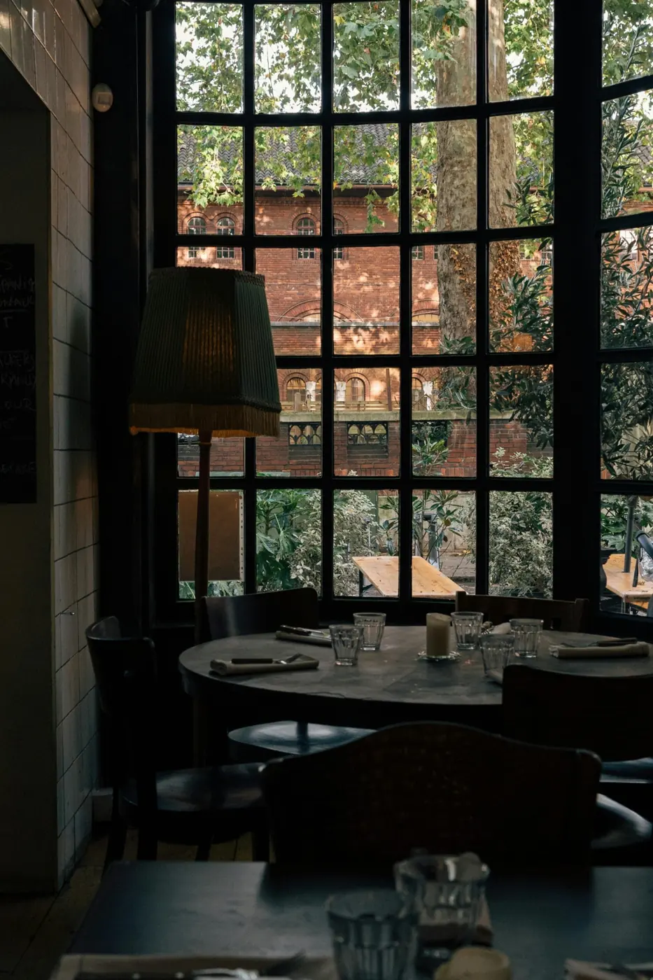 A candlelit restaurant dining room with tall windows